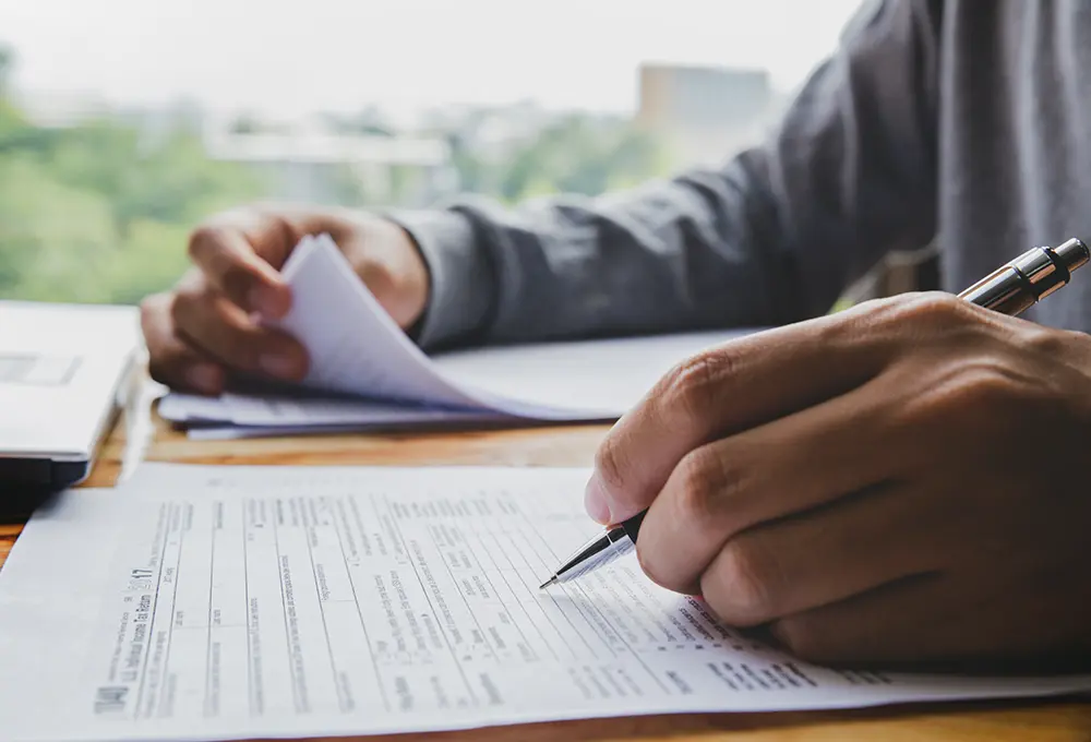 Person at desk filling out a tax form